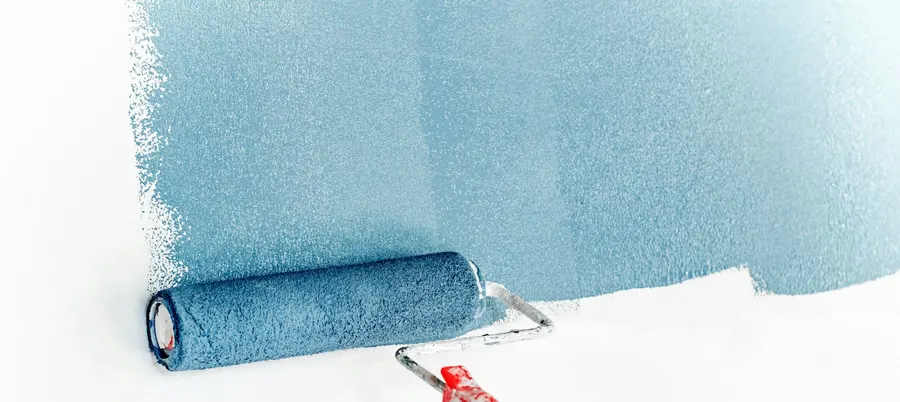 Paint roller applying light blue paint