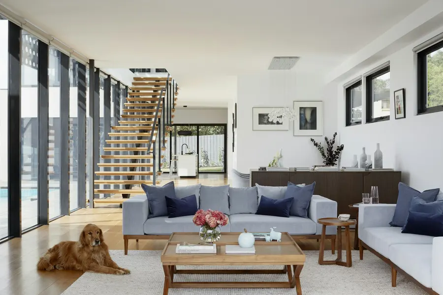 Living room with floor-to-ceiling windows and an open staircase