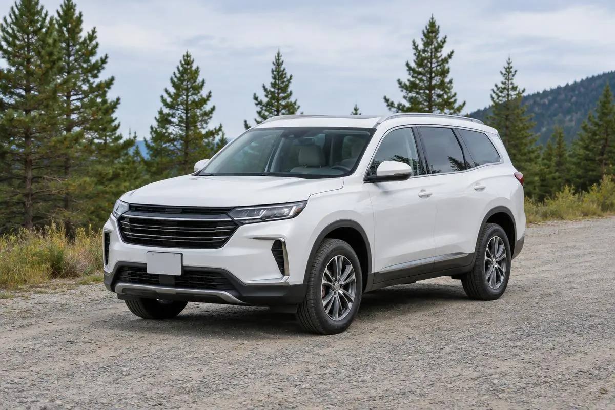 White three-row SUV parked on a gravel road among pine trees