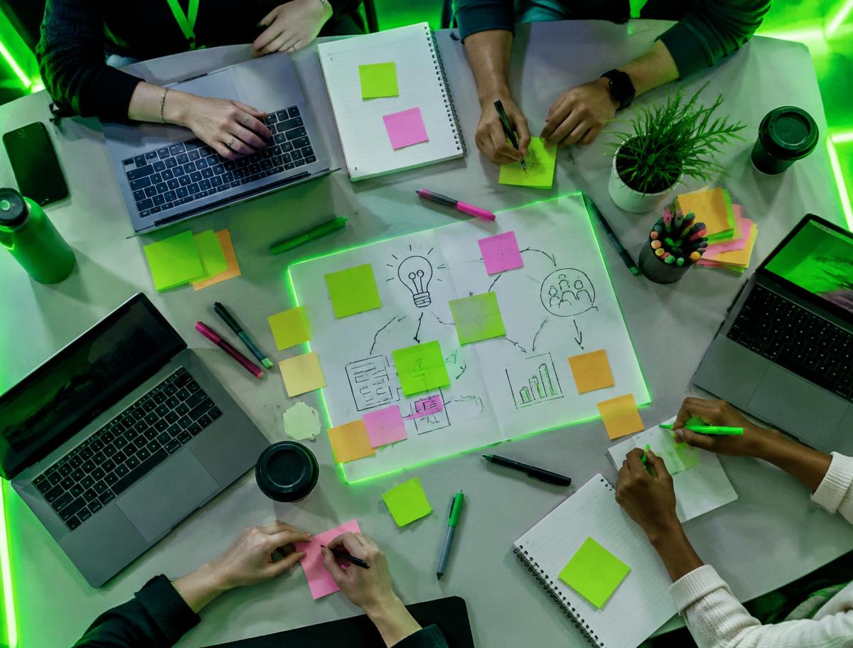 Overhead view of a workshop table with laptops and sticky notes